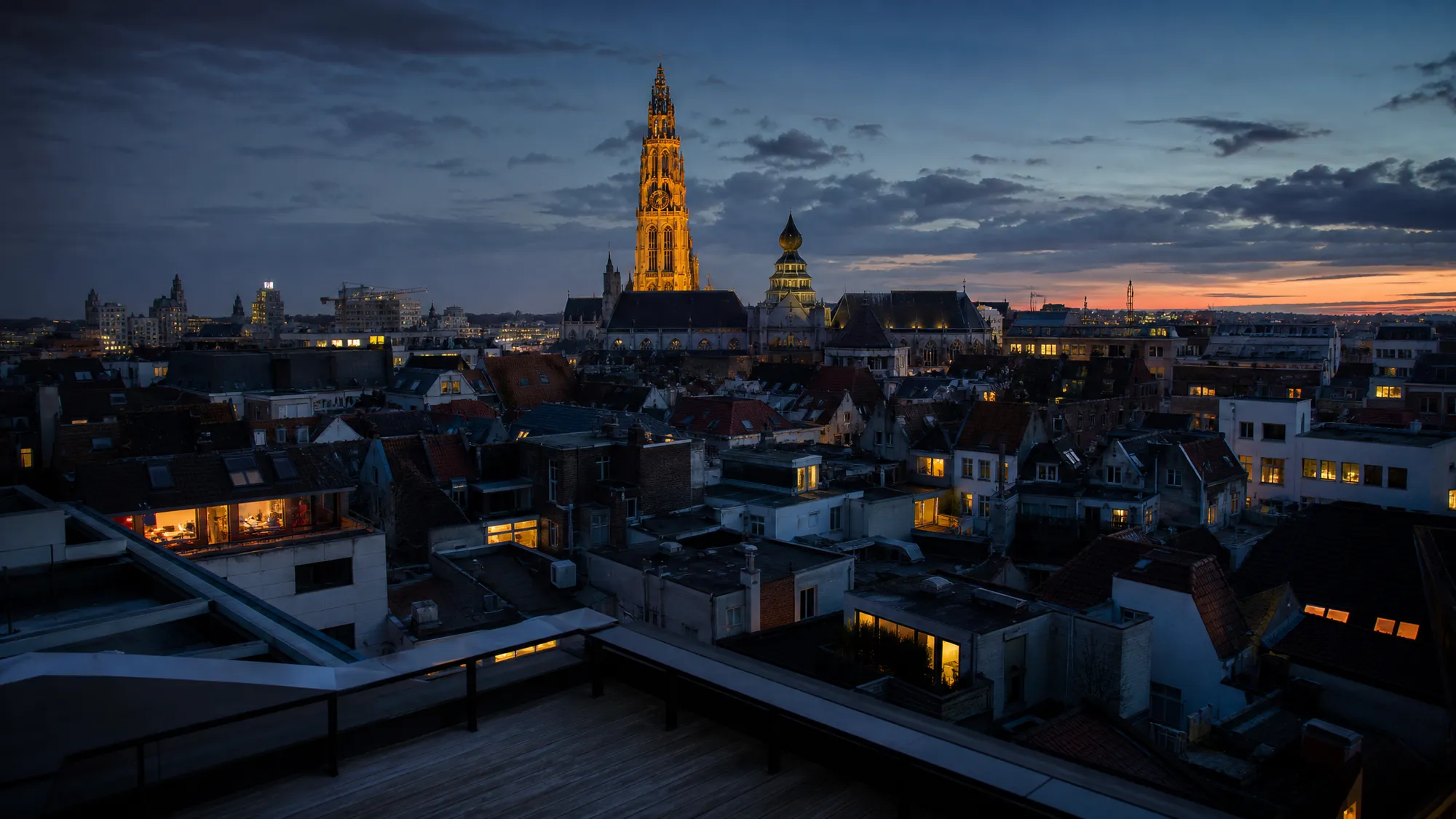 Daken van Antwerpen bij valavond met de verlichte toren van de Onze-Lieve-Vrouwekathedraal